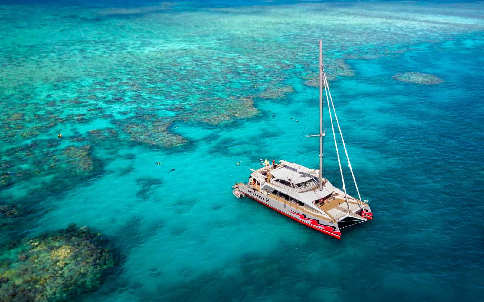 Cairns沖のGreat Barrier Reefに停泊するツアーボートと水中のシュノーケラー
