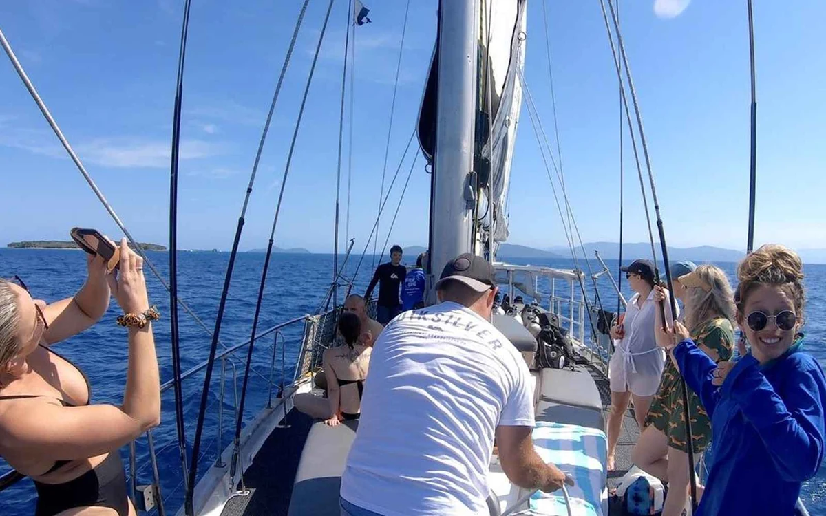 Ein Segelboot, das bei leichter Brise sanft auf offenem Wasser krängt