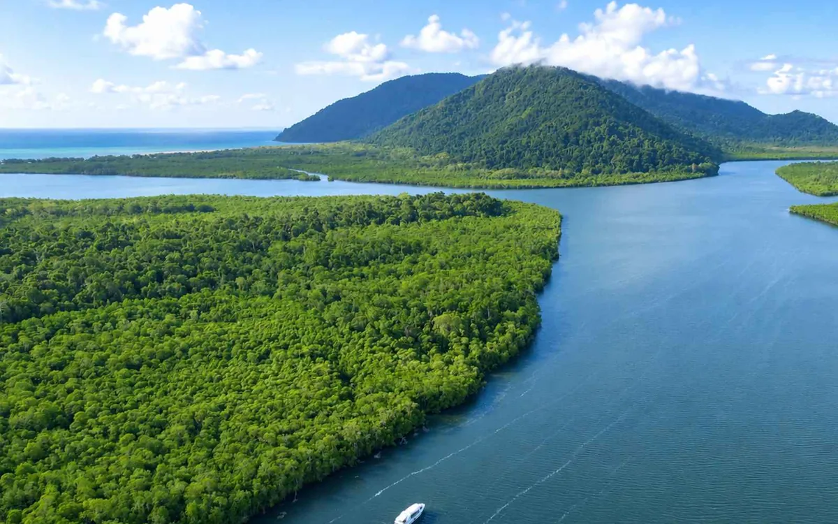 Un bateau de plongée amarré en eau bleu profond sur le récif extérieur, pont vide et plateforme de baignade abaissée